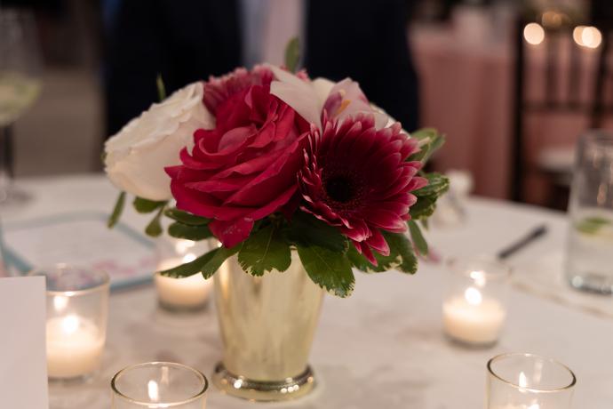 White and red flowers in a glass vase on white table top