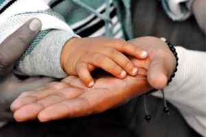 Mother's hand holding baby's hand